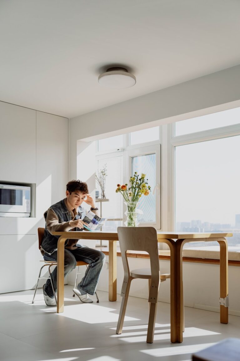 A man sitting at a table in front of a window